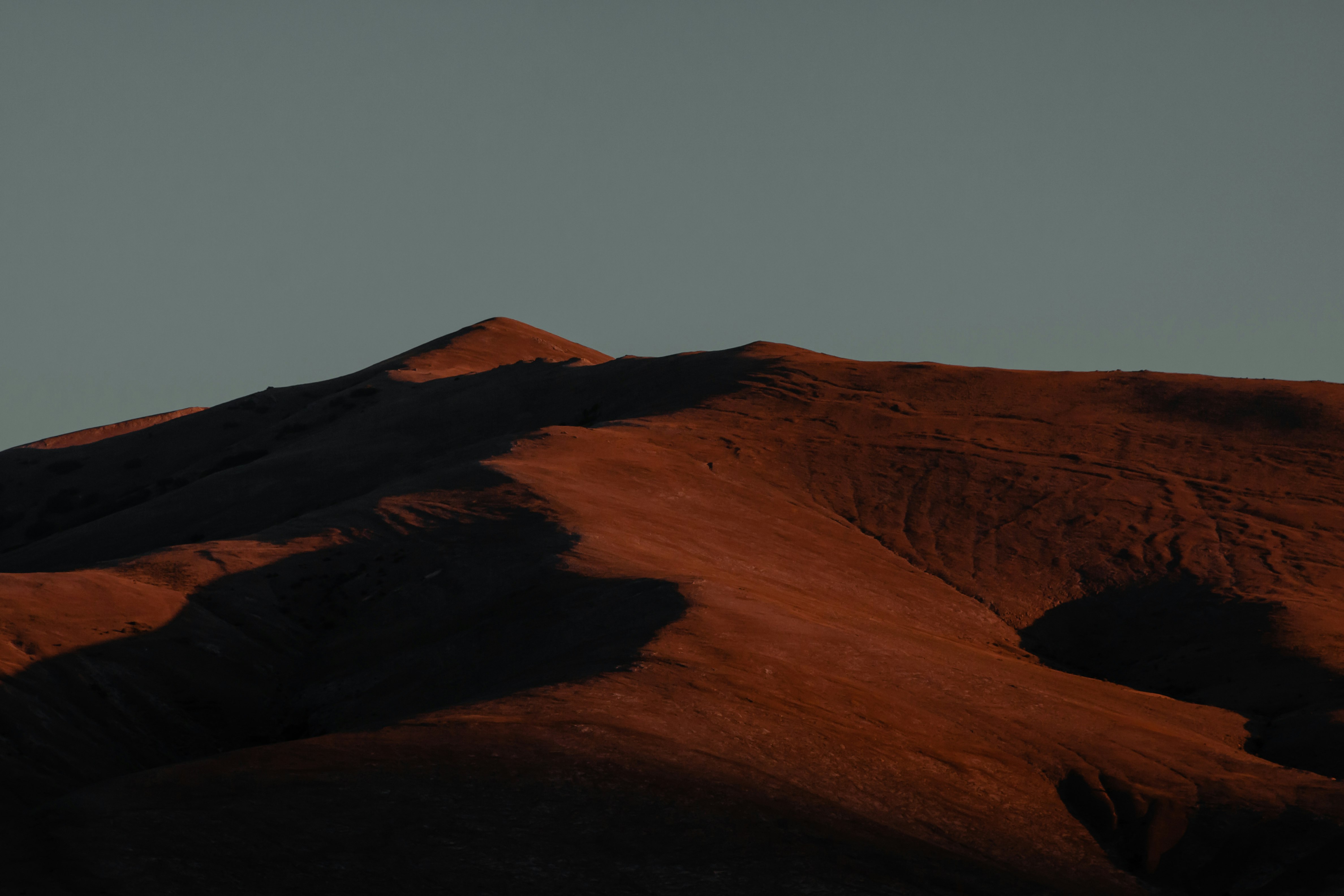 brown mountain under gray sky